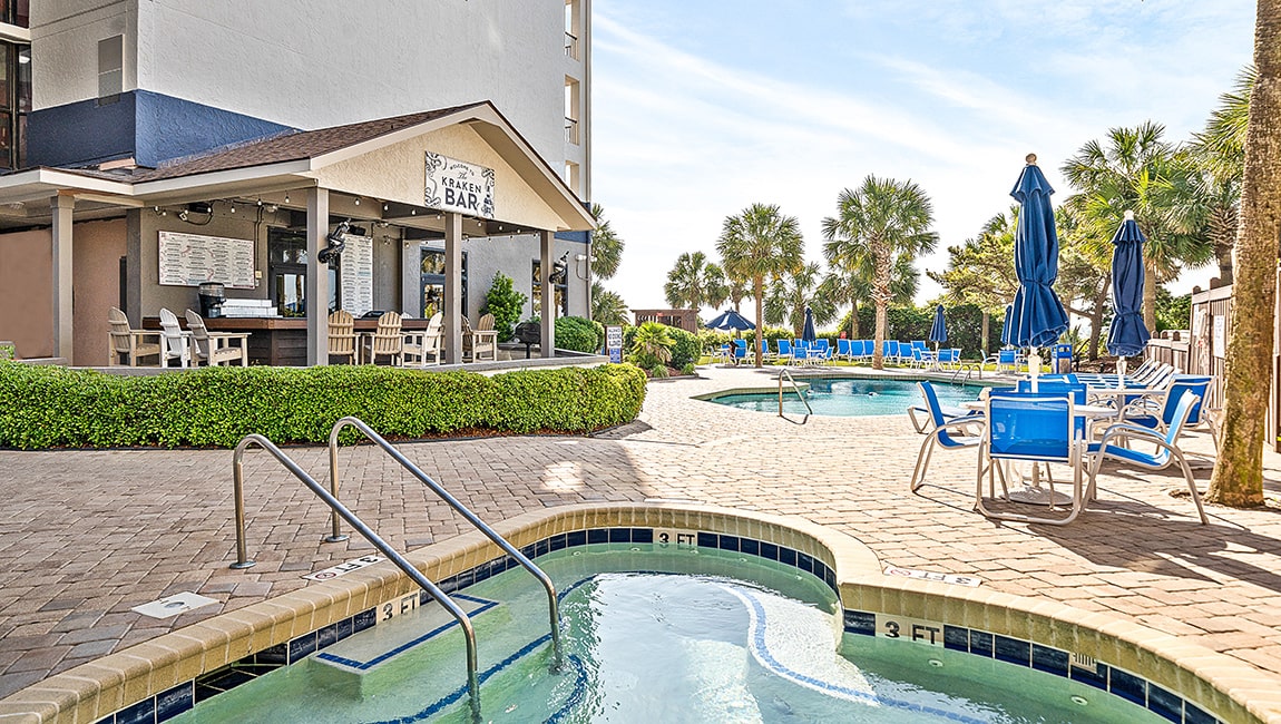 A hot tub and pool area with a bar and lounge chairs.